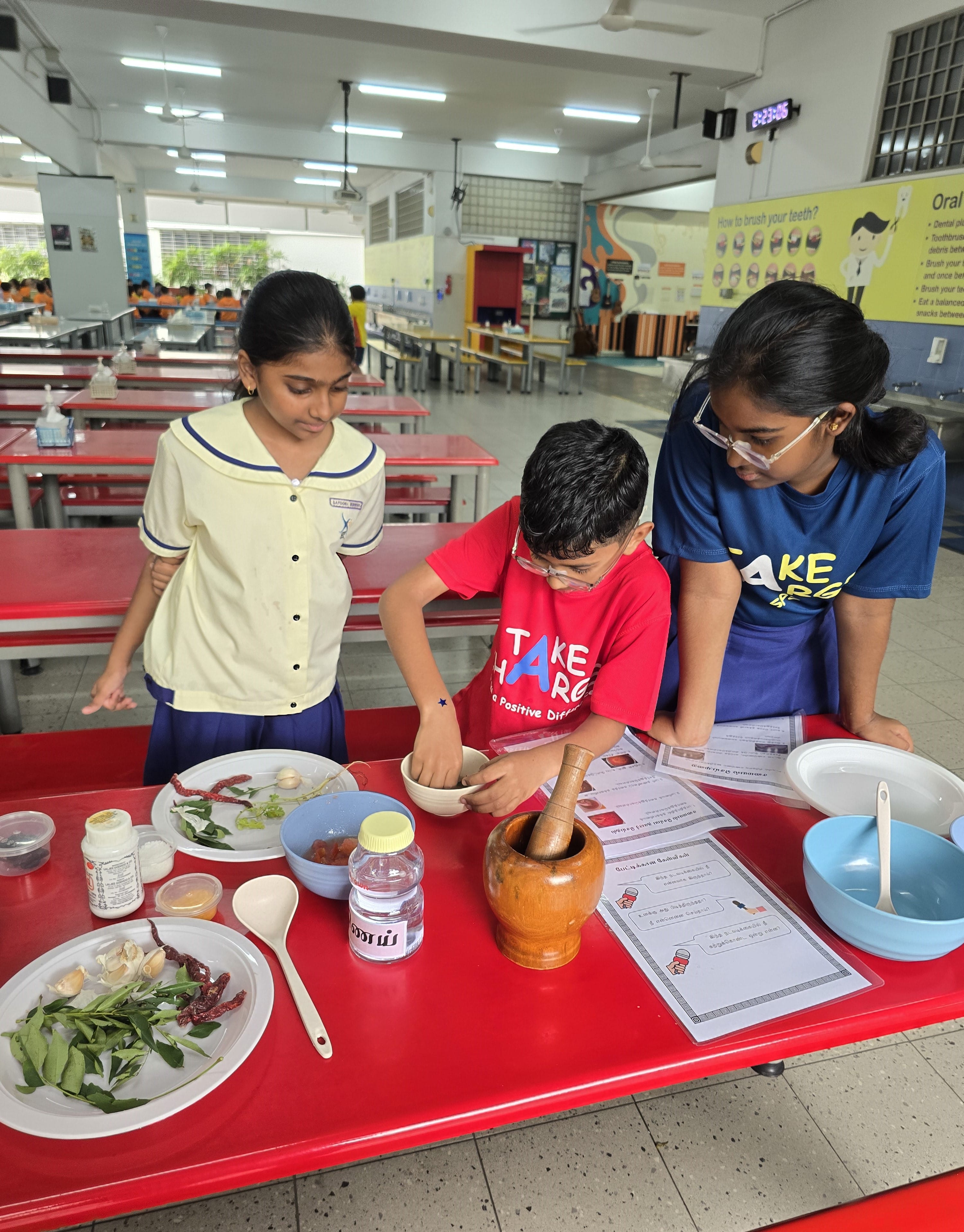 Three students gathered around mixing ingredients to make the perfect Rasam